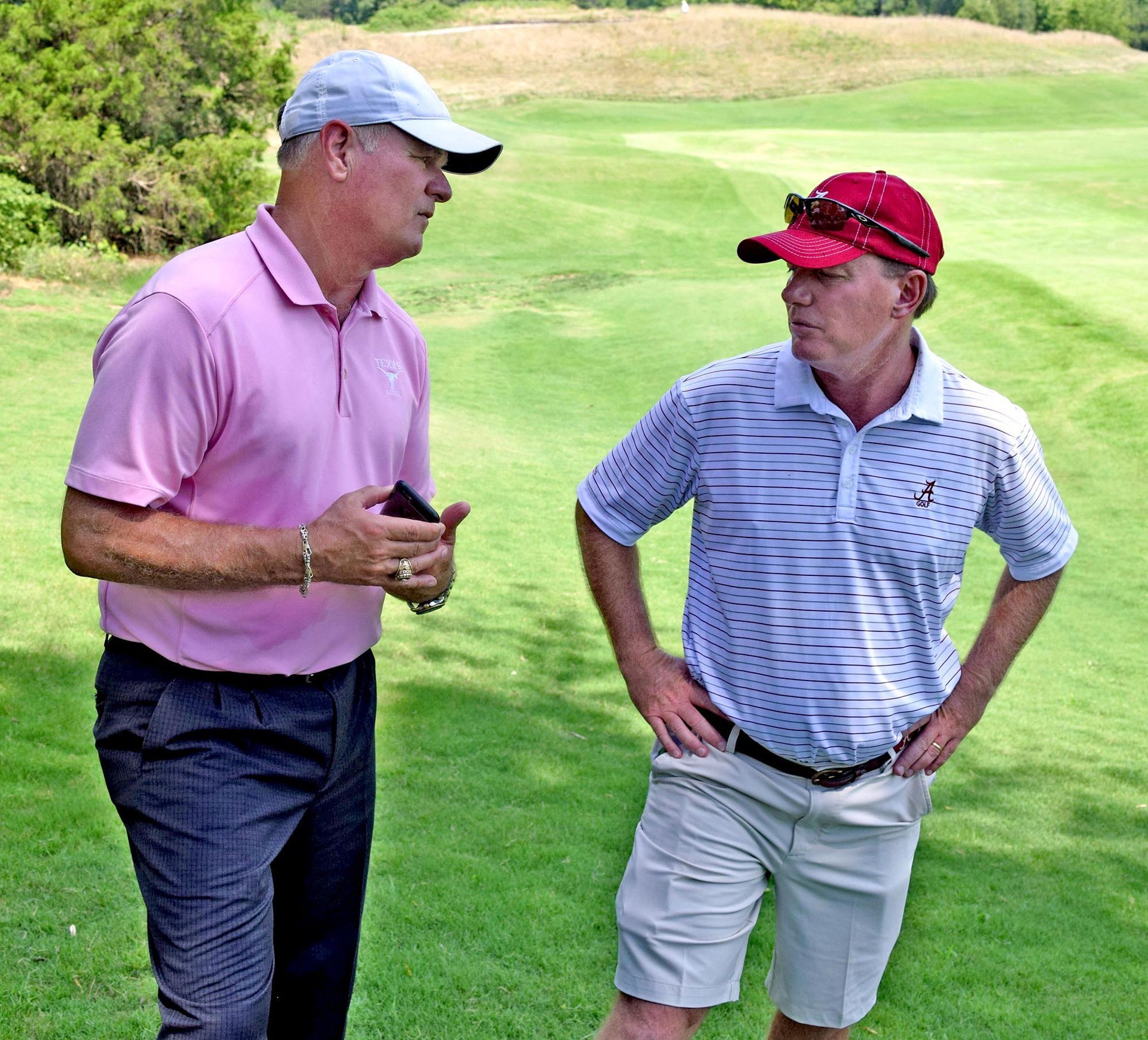 From left, University of Texas head coach, John Fields, talks with the University of Alabama's head coach, Jay Seawell, on the 11th hole. The third day of the 69th U.S. Junior Amateur Championship was held at the Honors Course in Ooltewah, Tennessee, Wednesday July 20, 2016.