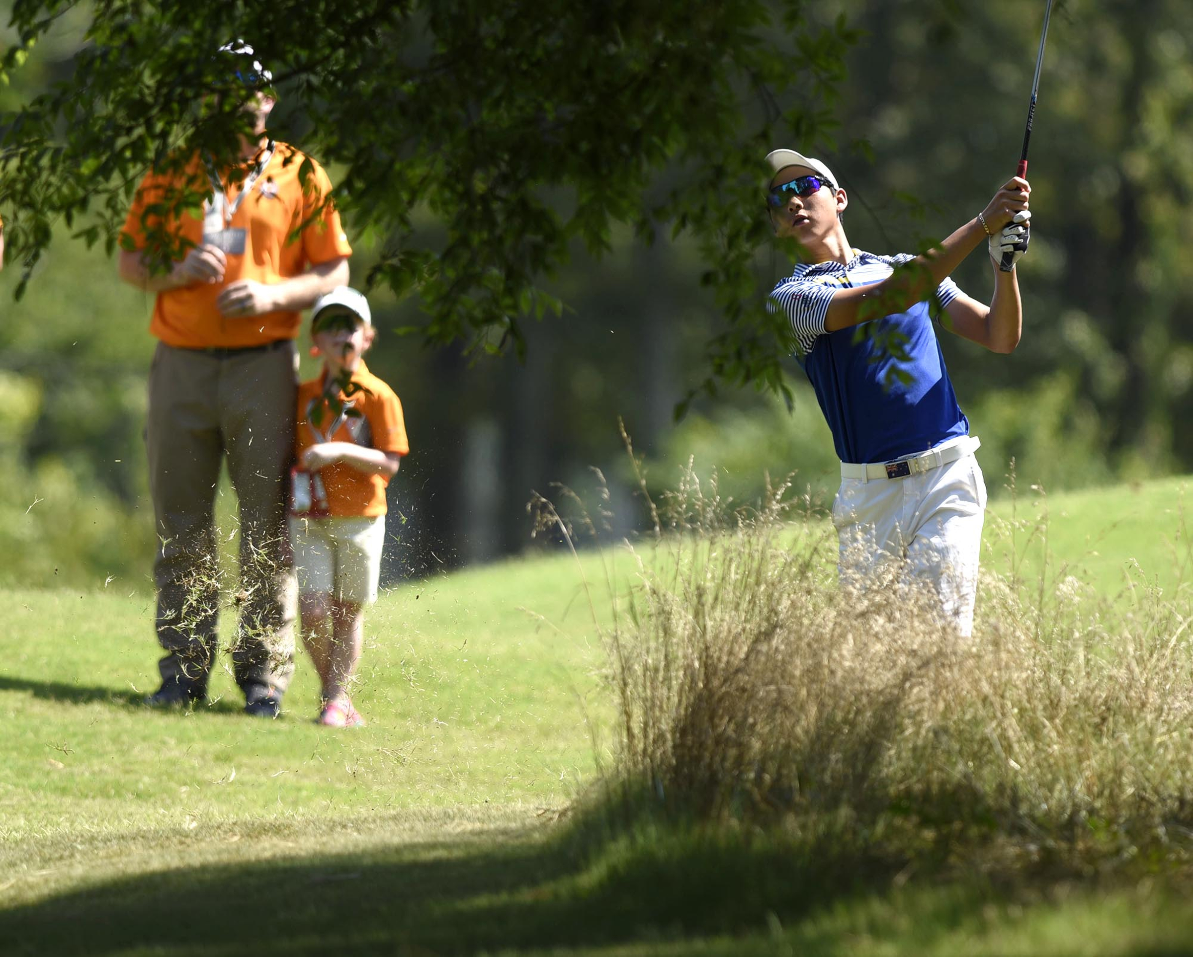 Australia's Min Woo Lee hits from under a tree on the 17th fairway. Lee defeted Chris Nido of Palmetto Bay, Florida. The third day of the 69th U.S. Junior Amateur Championship was held at the Honors Course in Ooltewah, Tennessee, Wednesday July 20, 2016.