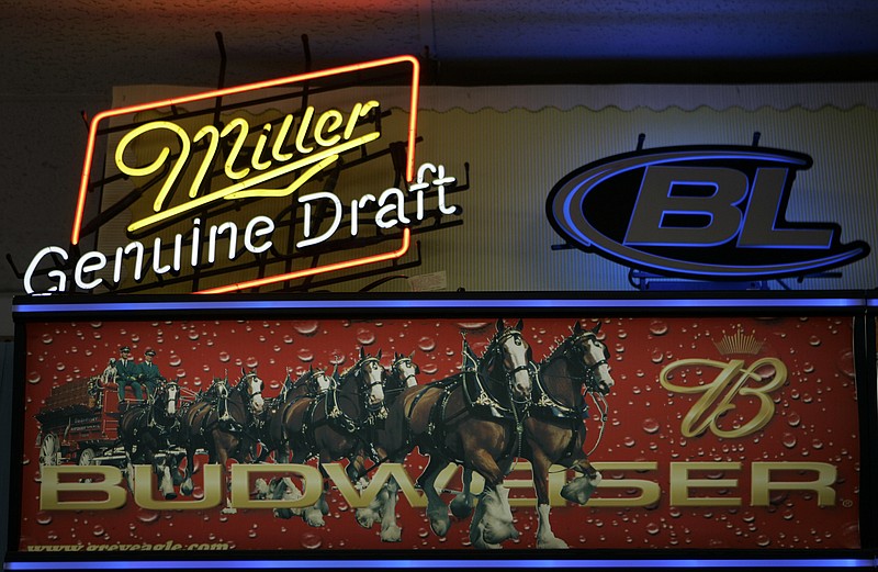 
              FILE - This Tuesday, Oct. 23, 2007, file photo shows signs for Miller and Anheuser-Busch products above a liquor store cooler in St. Louis. Anheuser-Busch InBev, the world's largest beer maker, announced Wednesday, July 20, 2016, that it has reached an agreement with the Justice Department clearing the way for U.S. approval of its acquisition of SABMiller. (AP Photo/Jeff Roberson, File)
            