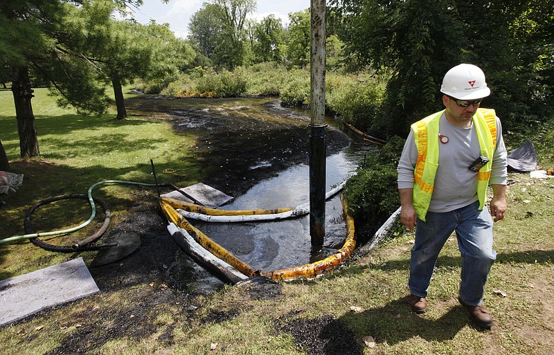 
              FILE - In this July 29, 2010 file photo, a worker monitors the water in Talmadge Creek in Marshall Township, Mich., near the Kalamazoo River as oil from a ruptured pipeline, owned by Enbridge Inc, is vacuumed out the water. Enbridge Energy Partners will pay a $61 million penalty for the costliest inland oil spill in U.S. history under an agreement with federal officials. The U.S. Environmental Protection Agency and the Department of Justice announced the settlement Wednesday, July 20, 2016. It involves a 2010 pipeline rupture near Marshall that released an estimated 843,000 gallons of crude oil. A nearly 40-mile stretch of the Kalamazoo River was polluted as shoreline residents fled their homes.(AP Photo/Paul Sancya, File)
            