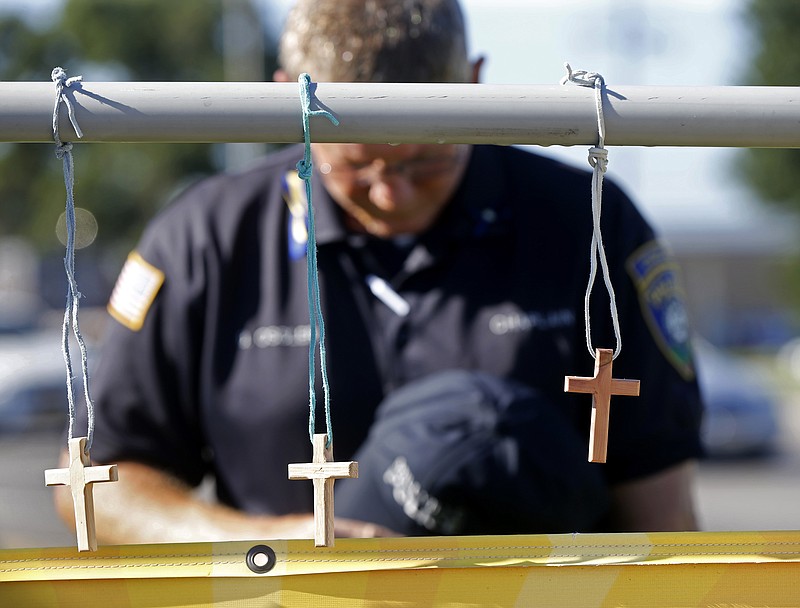 Millville, N.J., police chaplain Robert Ossler prays at a makeshift memorial at the fatal shooting scene in Baton Rouge, La., where several law enforcement officers were killed last weekend.