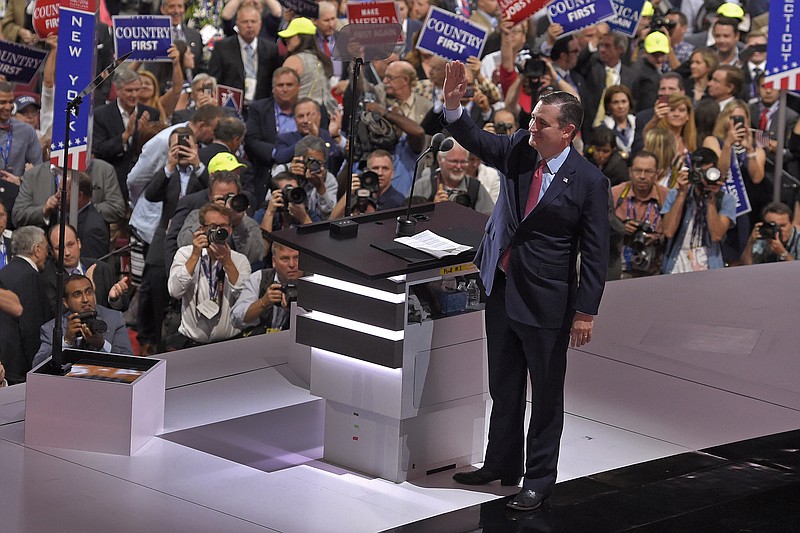 Before boos descended on him at the end of his speech, Sen. Ted Cruz, R-Texas, waves as he steps to the podium at Republican National Convention in Cleveland.