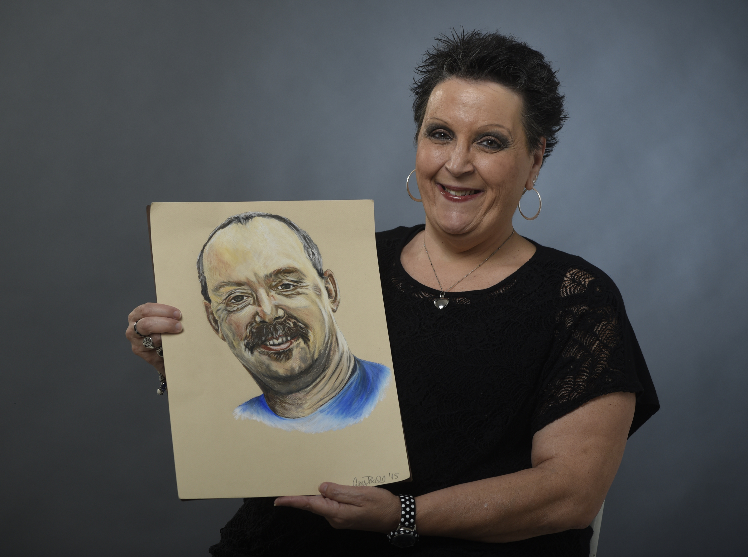 Wendy Roberts is photographed on Thursday, Mar. 31, 2016, in Chattanooga, Tenn., holding a portrait of her husband, Randy Roberts, who died of mesothelioma in Sept., 2011.