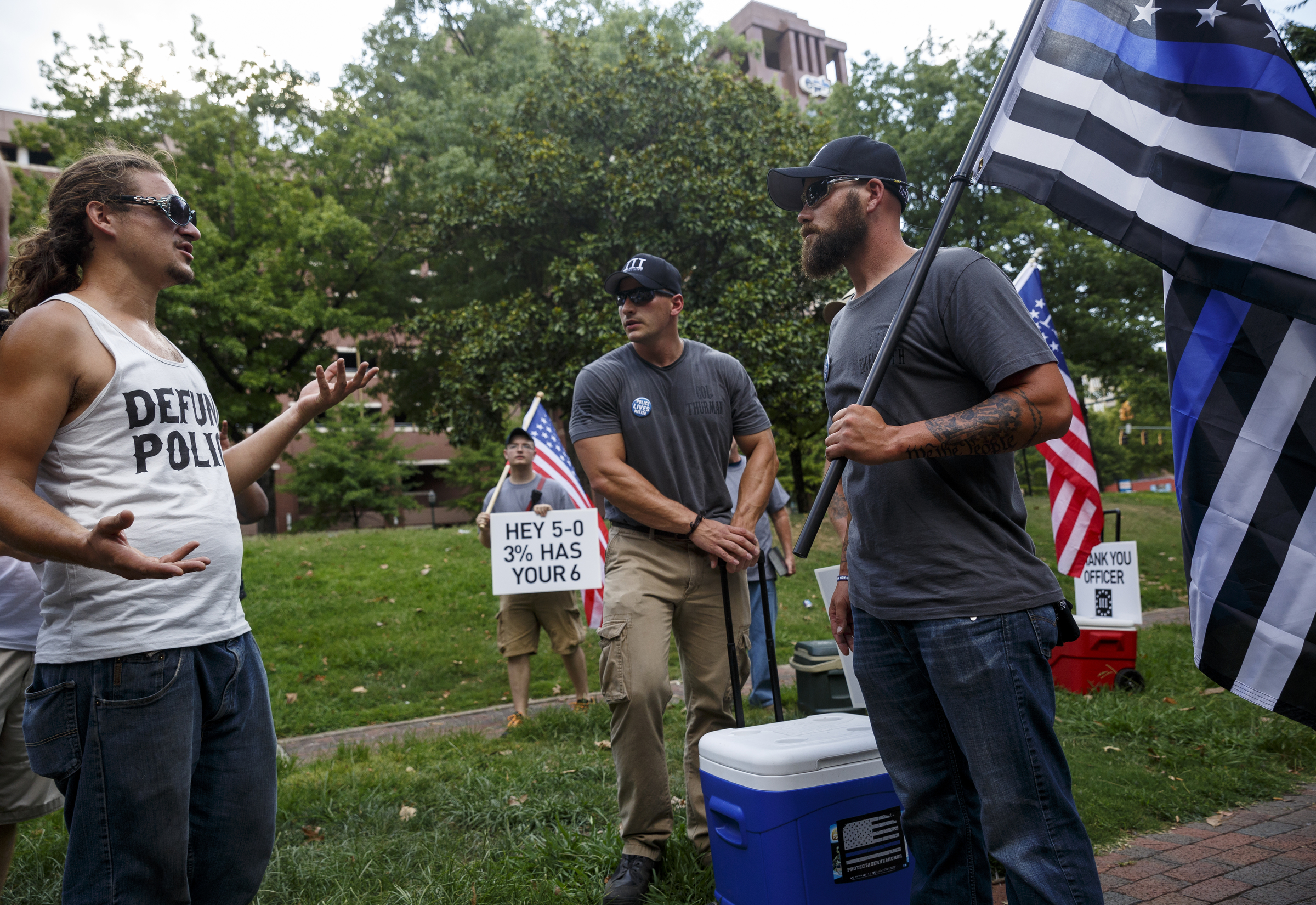 Matt Edgeworth, right, and Emanuel Thurman center, with the State of Tennessee 3% group, talk with protester Nathan King after offering water before a Black Lives Matter protest in Miller Park on Thursday, July 21, 2016, in Chattanooga, Tenn. The State of Tennessee 3% group showed up to the protest to support both police and to offer water to protesters.