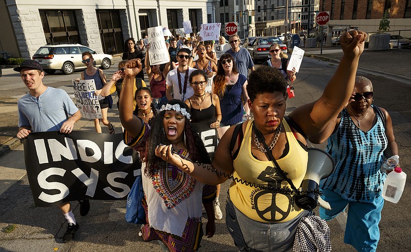 Protesters march on Walnut Street during a Black Lives Matter protest Thursday, July 21, 2016, in Chattanooga, Tenn. Protesters marched from Miller Park to the Tennessee Aquarium and back, stopping and blocking numerous intersections along the route.