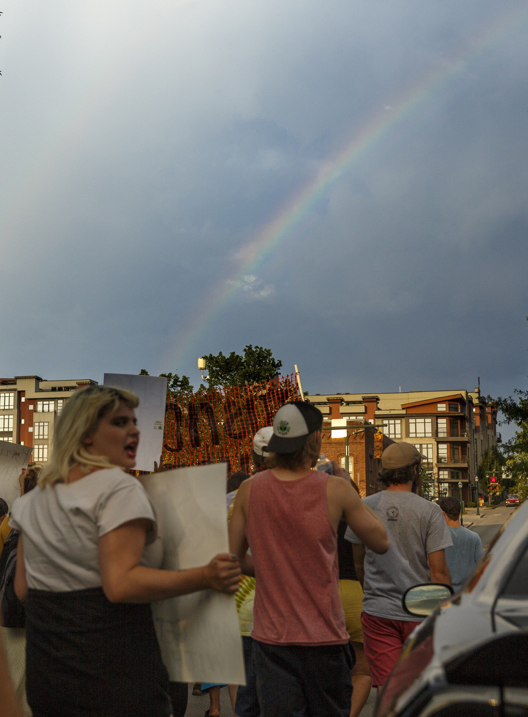 Protesters march on Aquarium Way as a rainbow is seen in the sky during a Black Lives Matter protest Thursday, July 21, 2016, in Chattanooga, Tenn. Protesters marched from Miller Park to the Tennessee Aquarium and back, stopping and blocking numerous intersections along the route.