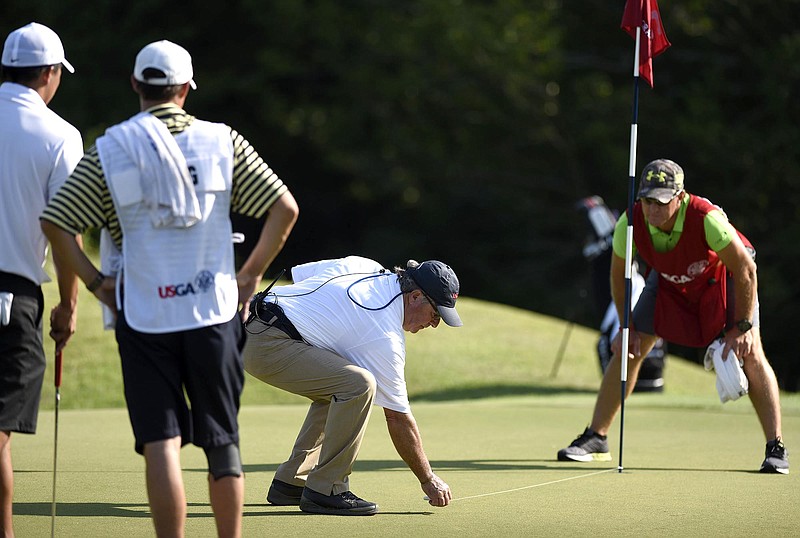 USGA Official Wayne Callahan uses a screen to determine which player is away, on the 6th green, in the match between Noah Goodwin and Norman Xiong during the round of 32.  The fourth day of the 69th U.S. Junior Amateur Championship was held at the Honors Course in Ooltewah, Tennessee, Thursday July 21, 2016. 