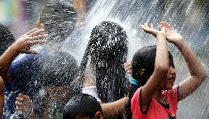 
              Children play in a water fall at the Crown Fountain in Chicago's Millennium Park, seeking temporary relief to the Midwest's excessive heat, Thursday, July 21, 2016, in Chicago. (AP Photo/Charles Rex Arbogast)
            