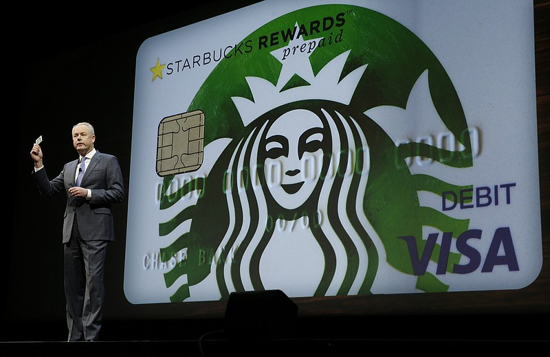 
              FILE - In this Wednesday, March 23, 2016, file photo, Kevin Johnson, president and chief operating officer of Starbucks Corp., holds up one of the coffee company's new prepaid Visa debit cards, at the coffee company's annual shareholders meeting in Seattle. Starbucks reports financial results Thursday, July 21, 2016. (AP Photo/Ted S. Warren, File)
            