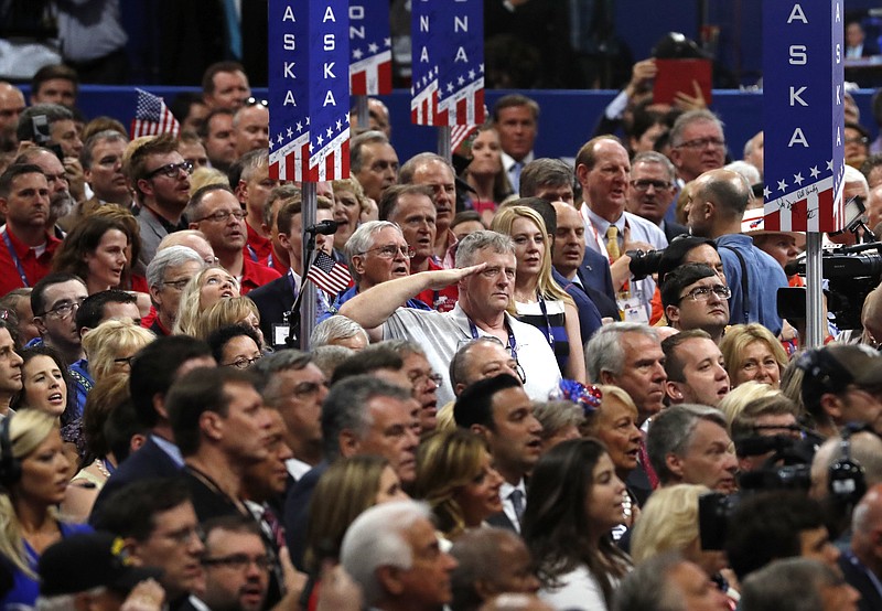 A man salutes during the singing of the National Anthem on the final day of the Republican National Convention in Cleveland, Thursday, July 21, 2016. (AP Photo/Paul Sancya)