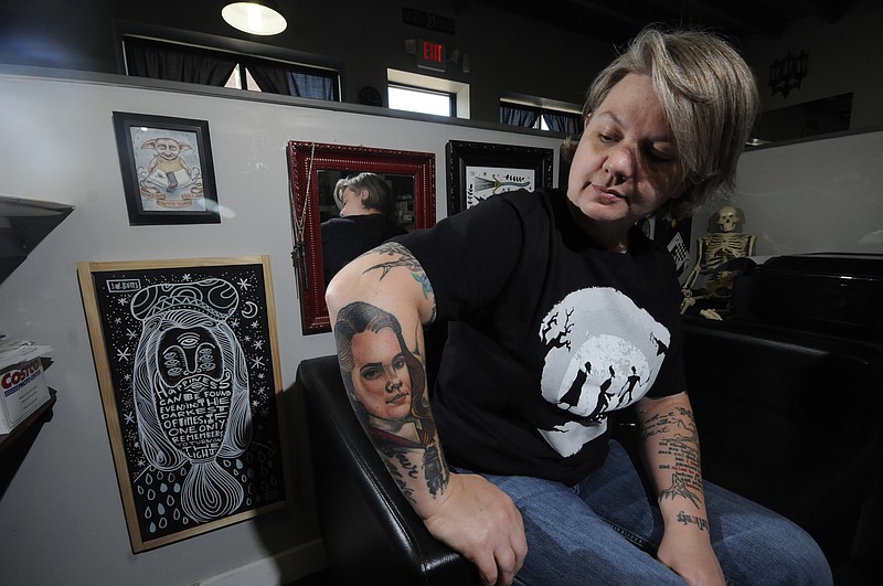 Jennifer Edge sports a Harry Potter tattoo on her right forearm in her booth surrounded by art from the Harry Potter series inside the shop at Main Line Ink on E. Main Street.