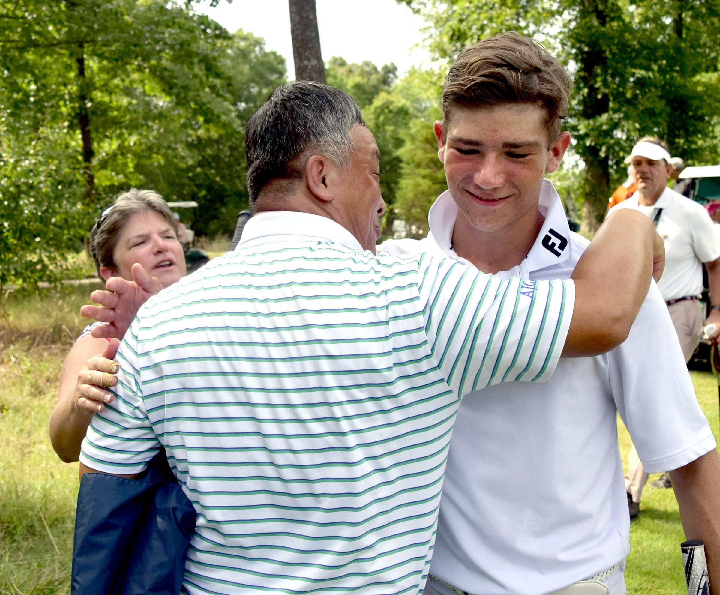 Semifinal winner, Noah Goodwin of Corinth, Texas is hugged by his opponent's father, Kwang Pak, while Goodwin's mother, Lisa, looks on.  Goodwin won his semifinal match over John Pak of Scotch Plains, New Jersey after 20 holes. The fifth day of the 69th U.S. Junior Amateur Championship was held at the Honors Course in Ooltewah, Tennessee, Friday July 22, 2016.