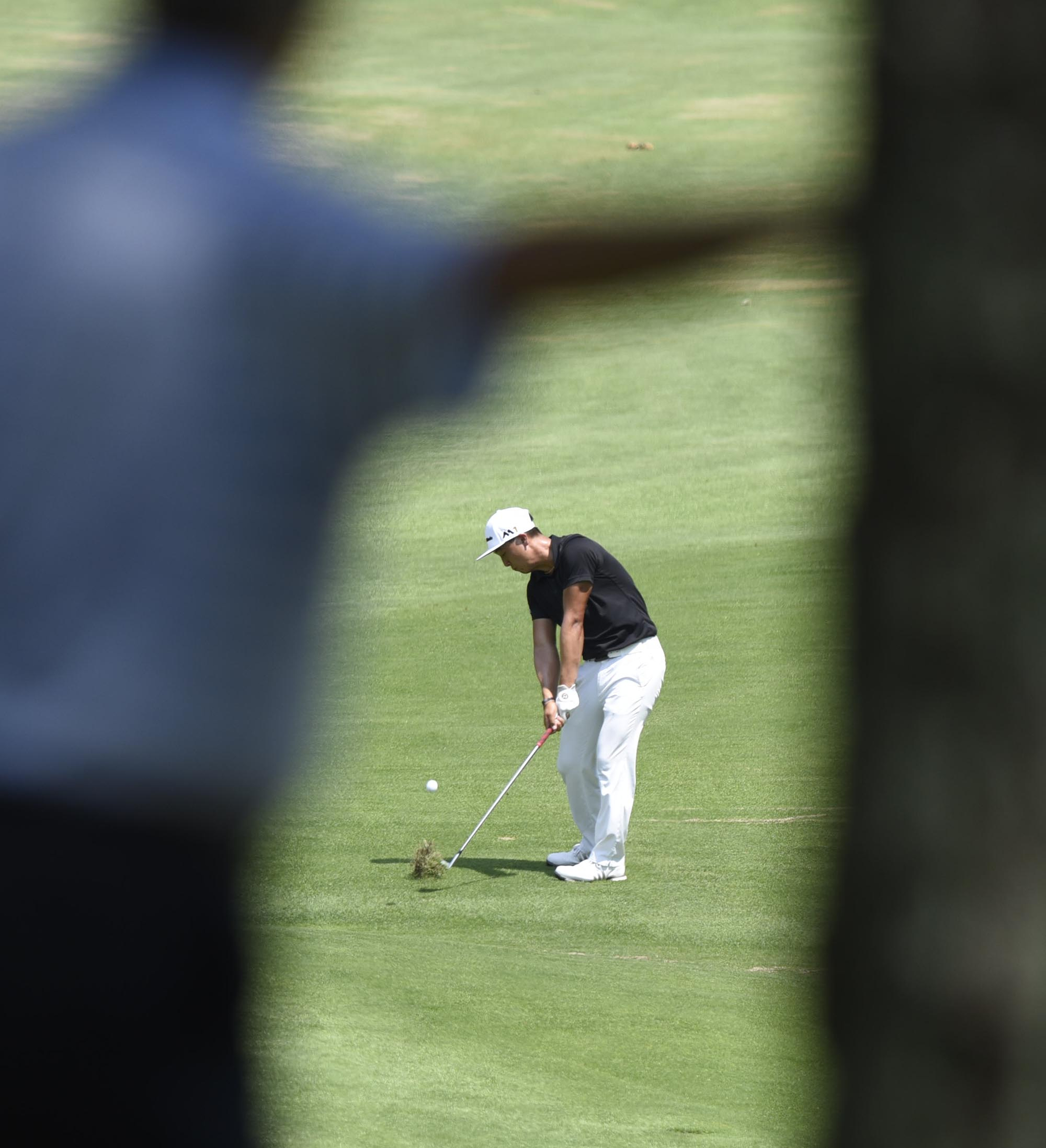 A spectator watches as John Pak of Scotch Plains, New Jersey hits his chip shot into the 13th green.  Pak lost his match to Noah Goodwin of Corinth, Texas after 20 holes.  The fifth day of the 69th U.S. Junior Amateur Championship was held at the Honors Course in Ooltewah, Tennessee, Friday July 22, 2016.
