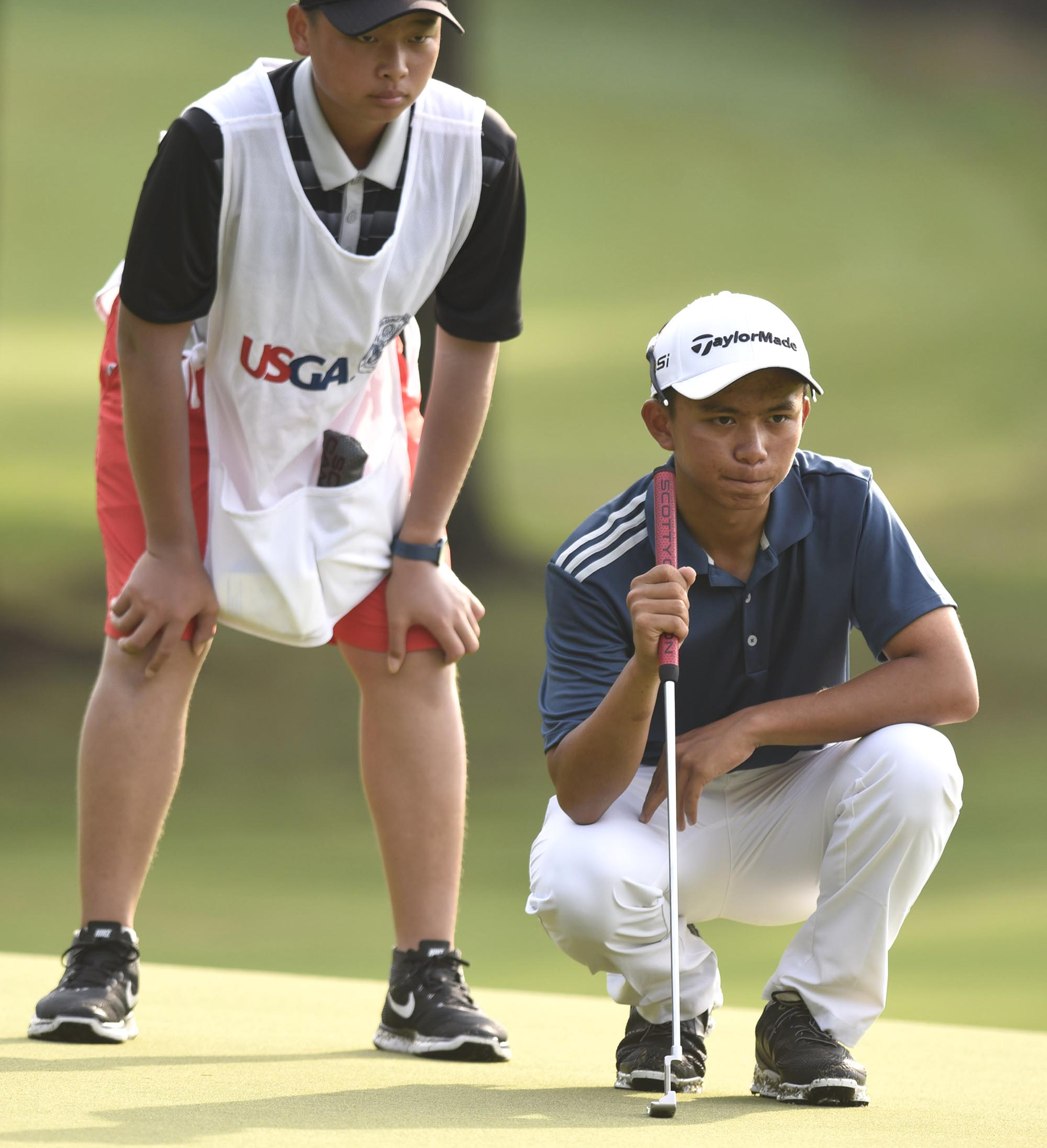 Wei Wei Gao of the Phillippines studies a putt on the 4th green with his caddie.  Gao lost his quarterfinal match to Eugene Hong of Sanford, Florida 1 up.   The fifth day of the 69th U.S. Junior Amateur Championship was held at the Honors Course in Ooltewah, Tennessee, Friday July 22, 2016.