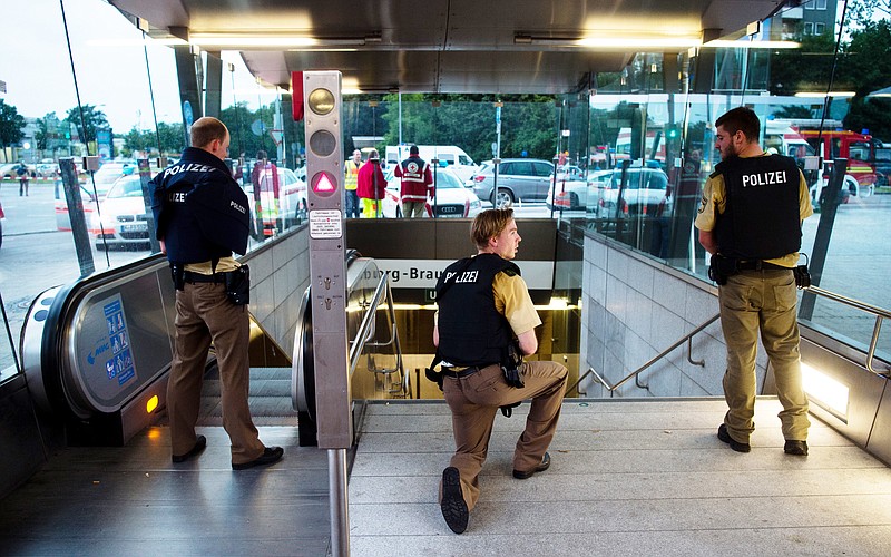 Policemen stand at the underground station Georg-Brauchle-Ring close to the Olympia shopping centre in which a shooting was reported in Munich, southern Germany, Friday July 22, 2016. According to media reports police expect several people being killed.