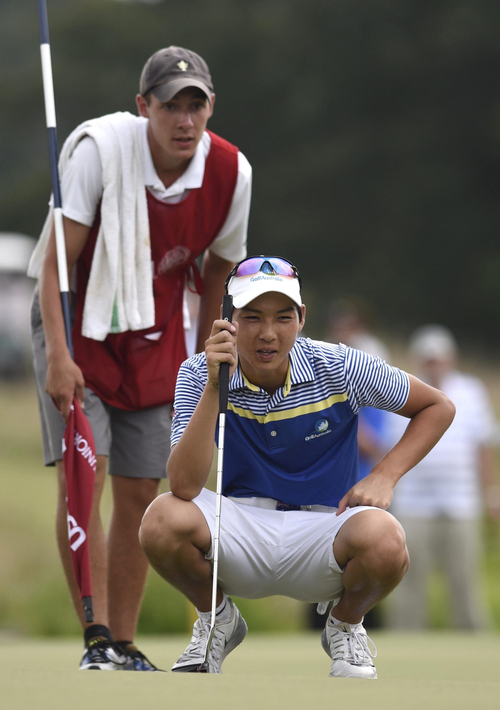 Australia's Min Woo Lee and his caddie, Reid Smith, look over Lee's putt on the 34th hole.  The final day of the 69th U.S. Junior Amateur Championship was held at the Honors Course in Ooltewah, Tennessee, Saturday July 23, 2016.