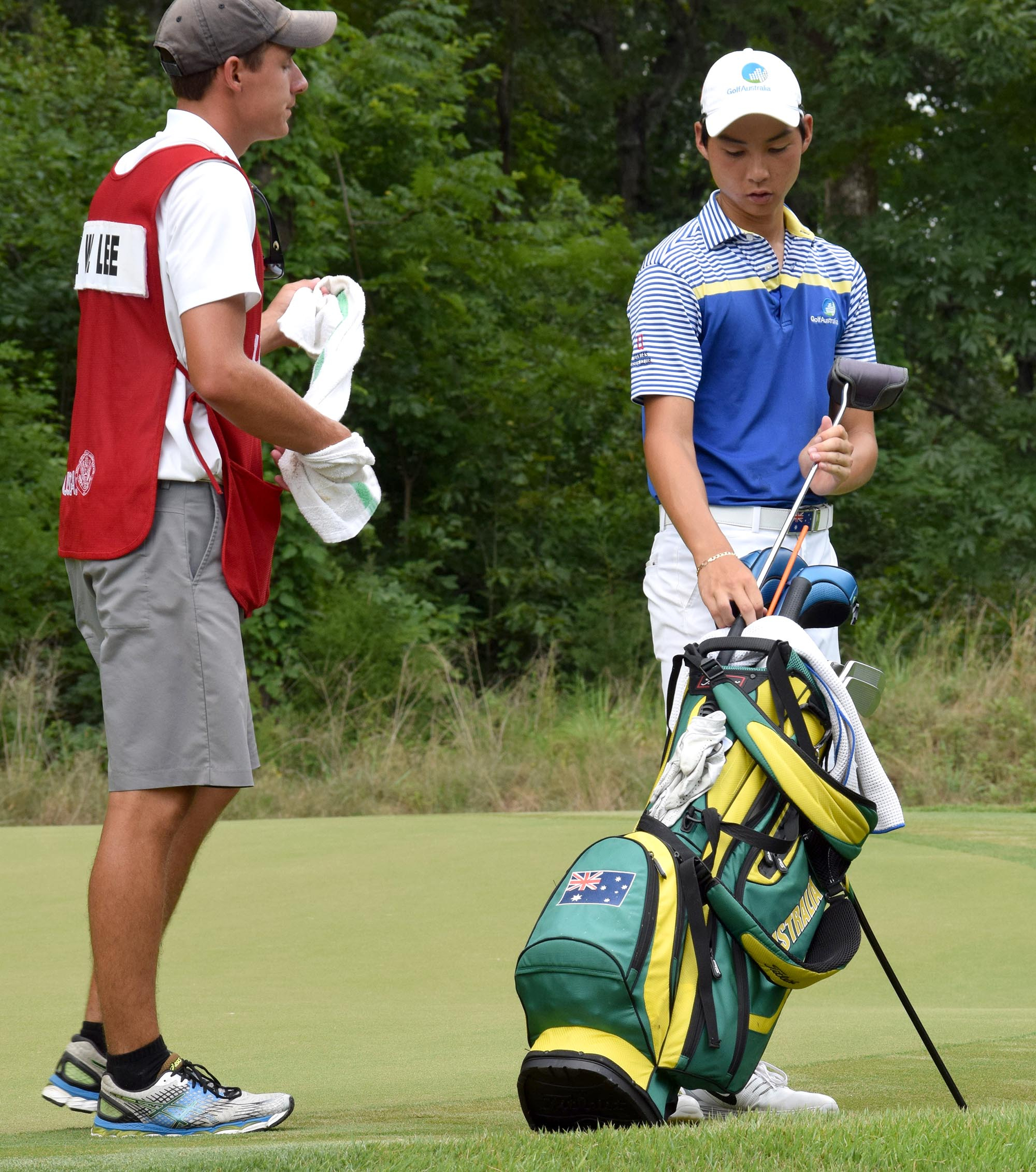 Australia's Min Woo Lee puts his putter into the bag, while caddie Reid Smith looks on, after play is delayed because of weather.  The final day of the 69th U.S. Junior Amateur Championship was held at the Honors Course in Ooltewah, Tennessee, Saturday July 23, 2016.