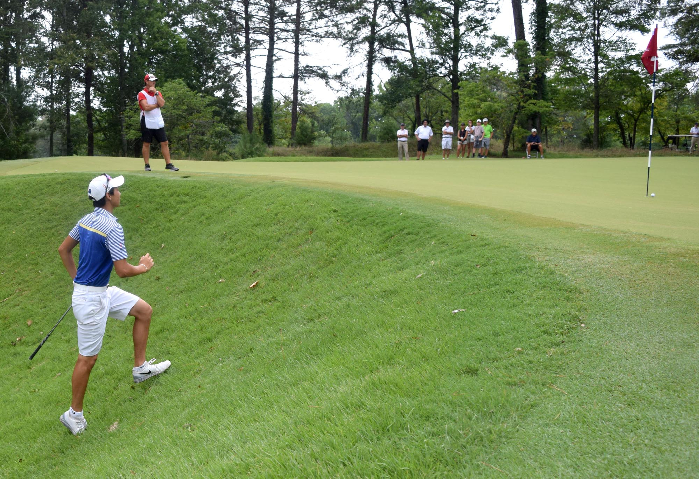 Min Woo Lee runs up the side hill on the 35th hole to find his chip shot 3 1/2 feet from the hole.  Lee would make the put to clinch the championship.  The final day of the 69th U.S. Junior Amateur Championship was held at the Honors Course in Ooltewah, Tennessee, Saturday July 23, 2016.