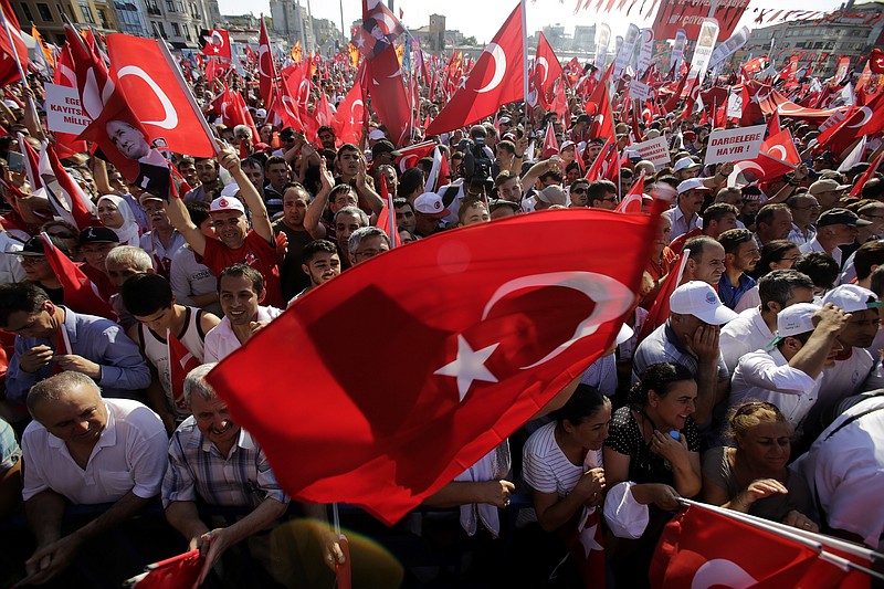 
              A supporter of the Republican People's Party, or CHP, waves a Turkish flag bearing a portrait of Mustafa Kemal Ataturk, the founder of modern Turkey, during a 'Republic and Democracy Rally' at Taksim square in central Istanbul, Sunday, July 24, 2016. Thousands of supporters of Turkey's main opposition group and some ruling party members rallied in Istanbul to denounce a July 15 coup attempt, a rare show of political unity that belied opposition unease over President Recep Tayyip Erdogan's crackdown since the failed uprising. (AP Photo/Petros Karadjias)
            