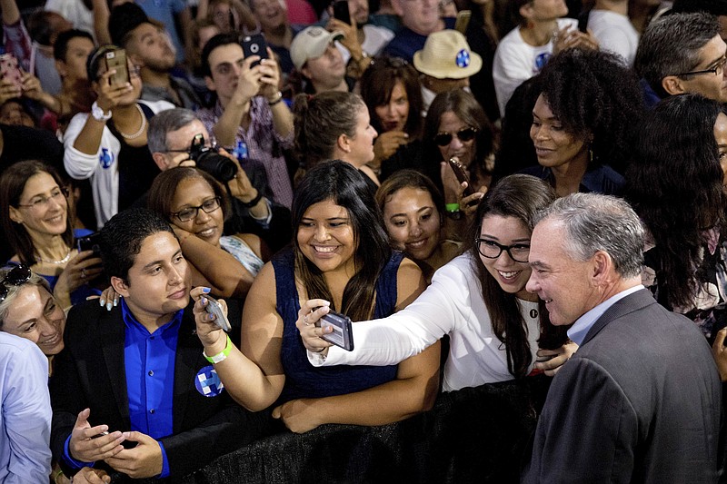 Sen. Tim Kaine, D-Va., takes a photograph with a member of the audience after speaking at a rally with Democratic presidential candidate Hillary Clinton at Florida International University on Saturday.
