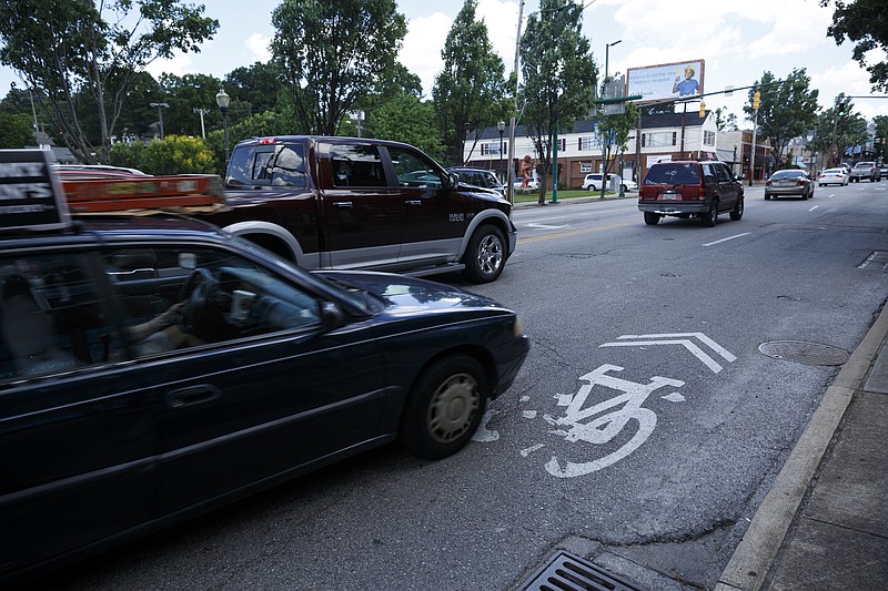 A car drives over a bike lane marker on Frazier Avenue in this June photo. The city is scrapping a proposal for permanent bike lanes on the congested North Shore street after local business owners objected.