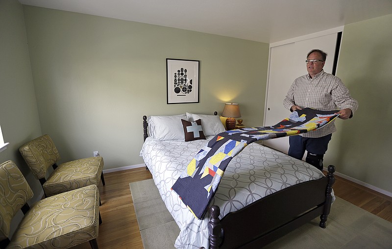 
              FILE - In this Oct. 16, 2015 file photo, Bruce Bennett folds a blanket in a room that he makes available to rent in he and his husband's home in San Francisco. Supervisors in a city nearly synonymous with the internet say an ordinance requiring Airbnb and other short-term rental platforms to list only legal units or face steep fines is a simple change to existing law. Airbnb, however, says the new regulation challenges the heart of what makes the internet the flourishing, free-wheeling frontier it is: that internet platforms, such as Facebook and Twitter, cannot be sued or punished for the content posted by third-party hosts. (AP Photo/Ben Margot, File)
            