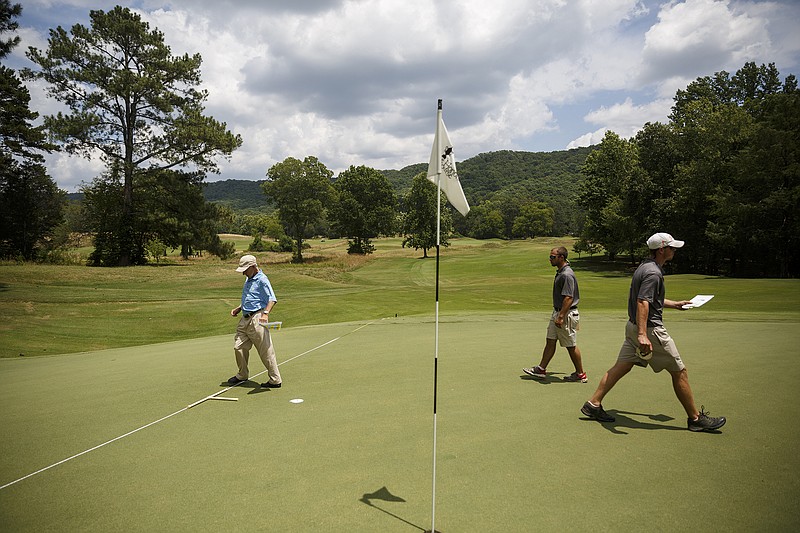 Staff photo by Doug StricklandDavid Stone, left, Jarred Walker, center, and Joey Glisson work to determine hole placement for an upcoming tournament at the 13th green of The Honors Course in Chattanooga.