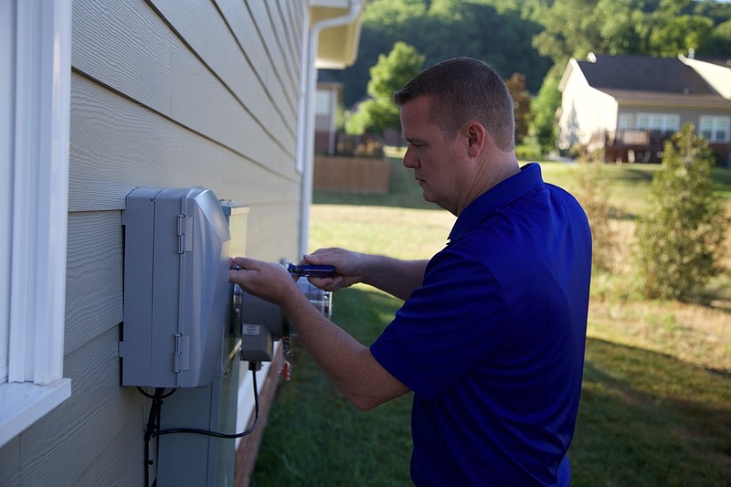 EPB's Shane Wallin works on an installation outside the home of Angela Marks.