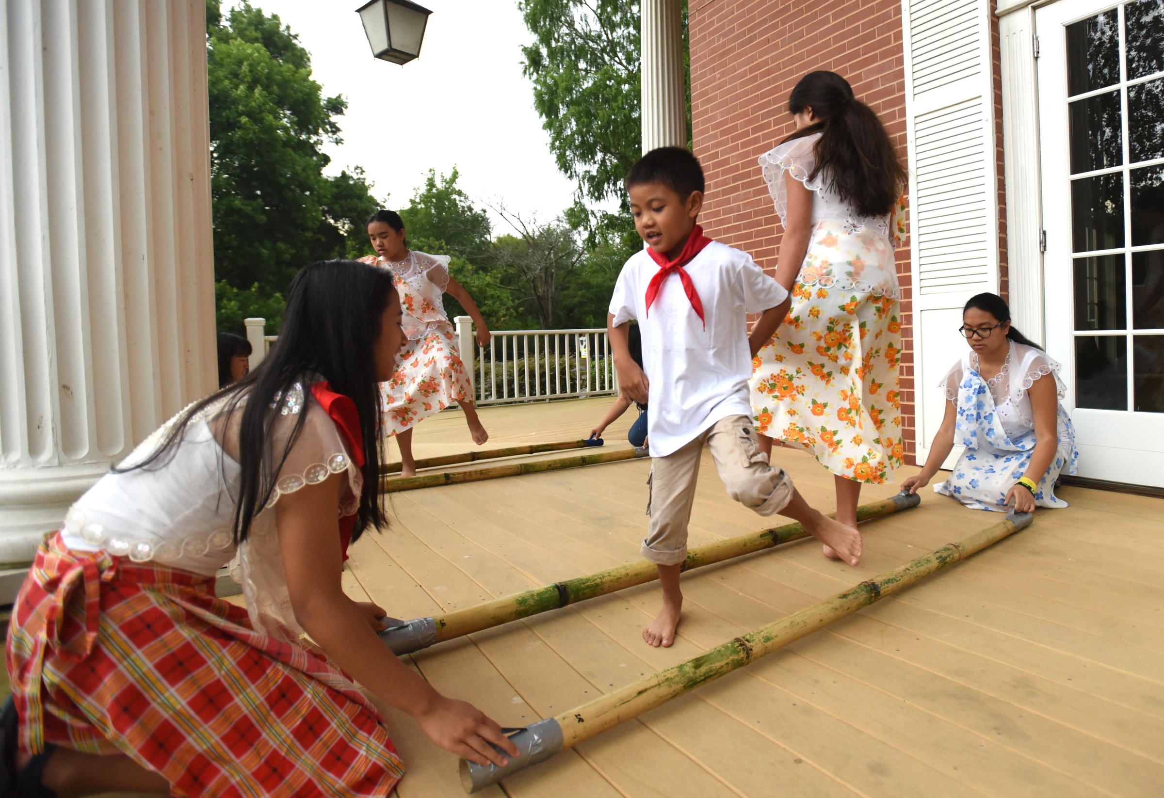Juliana Gonzalez, left, and Ally Pendon, right, tap the sticks as Brienn Daniel Ayerdi, second from left, and Lexi Gowan demonstrate Tinikling, the national dance of the Philippines, Monday, June 27, 2016 at Heritage Park.