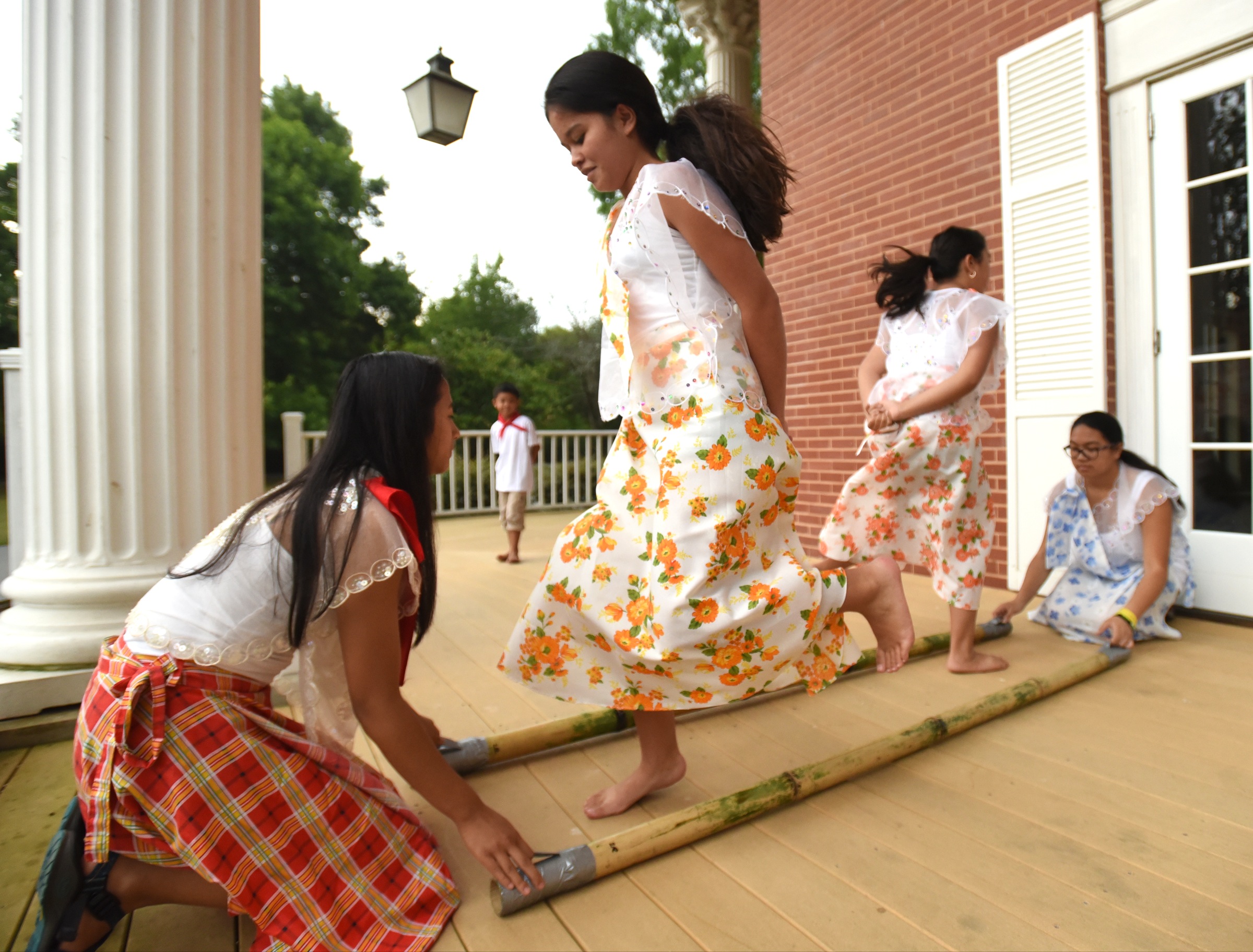 Juliana Gonzalez, left, and Ally Pendon, right, tap the sticks as Lexi Gowan, second from left, and Becca Pendon demonstrate Tinikling, the national dance of the Philippines, Monday, June 27, 2016 at Heritage Park.