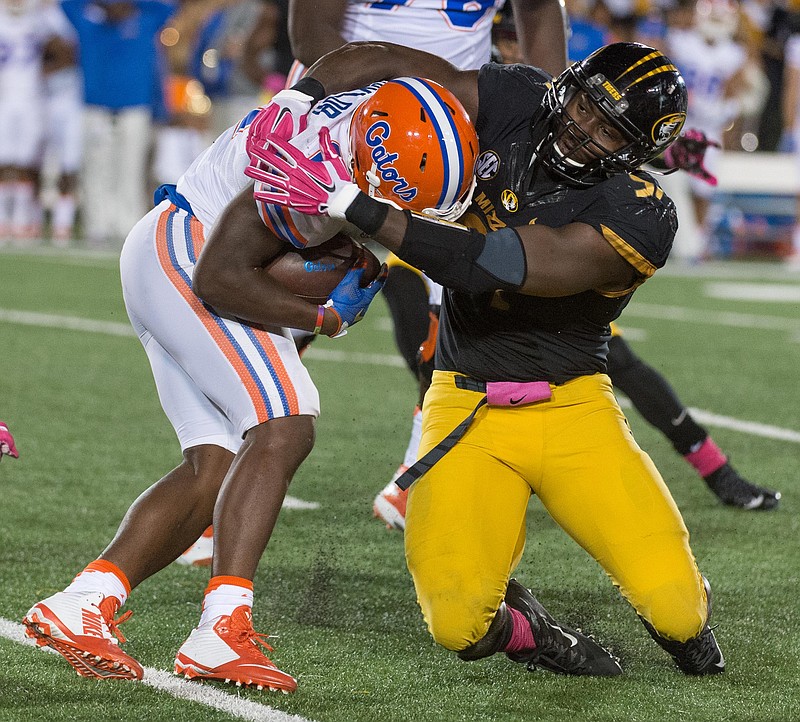 Florida running back Kelvin Taylor, left, is tackled by Missouri's Charles Harris, right, during the first half of an NCAA college football game, Saturday, Oct. 10 2015, in Columbia, Mo.  (AP Photo/L.G. Patterson)