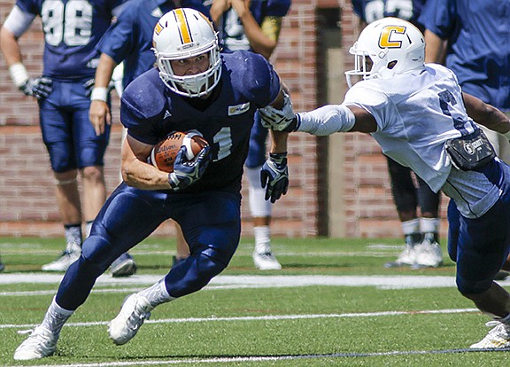 Blue team running back Derrick Craine breaks a tackle by white team defensive back C.J. Fritz during the UTC spring football game at Finley Stadium on Saturday, April 23, 2016, in Chattanooga, Tenn.