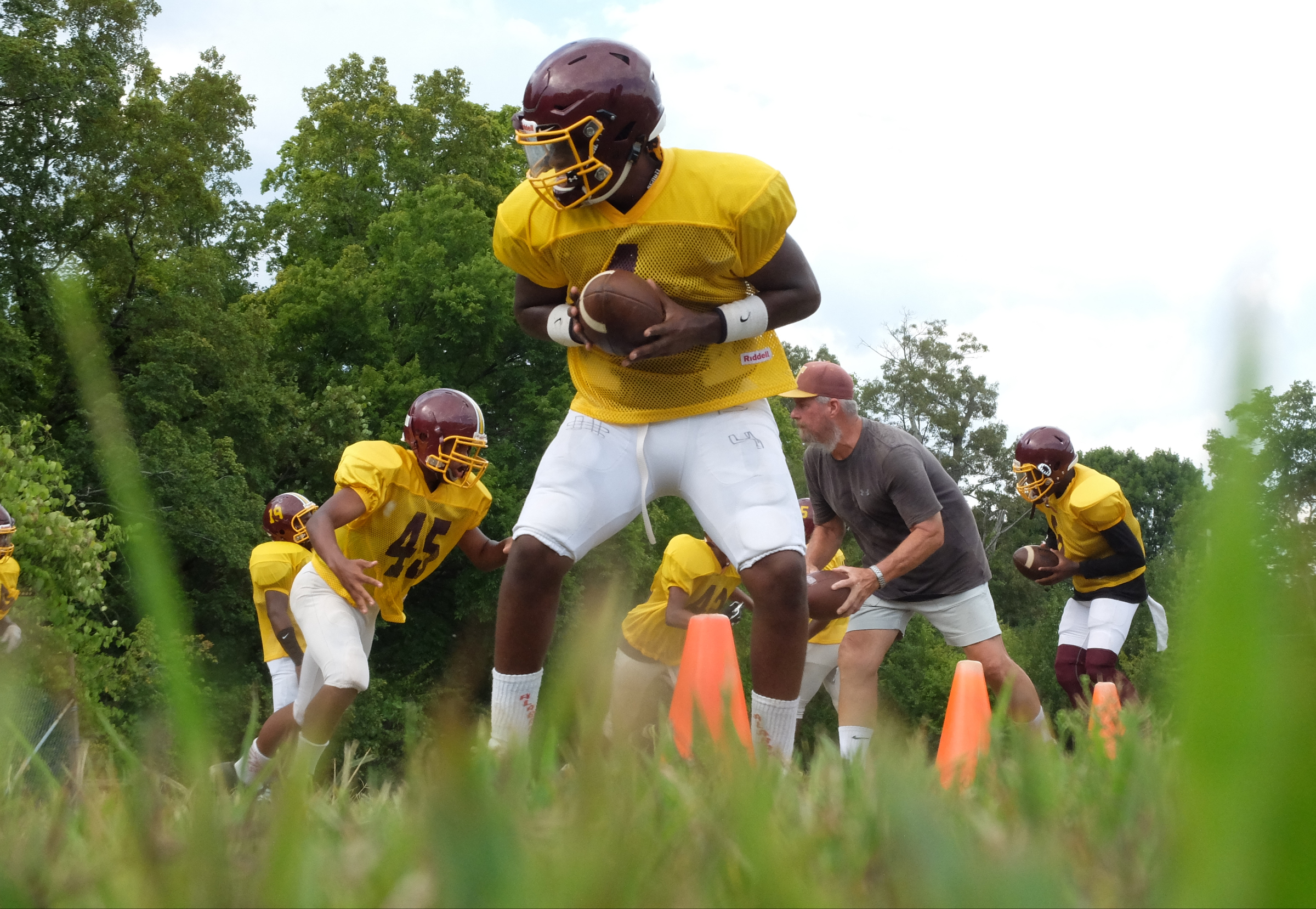 Tyner Coach Wayne Turner, second from right, prepares to hand off working his running backs during practice on Monday.