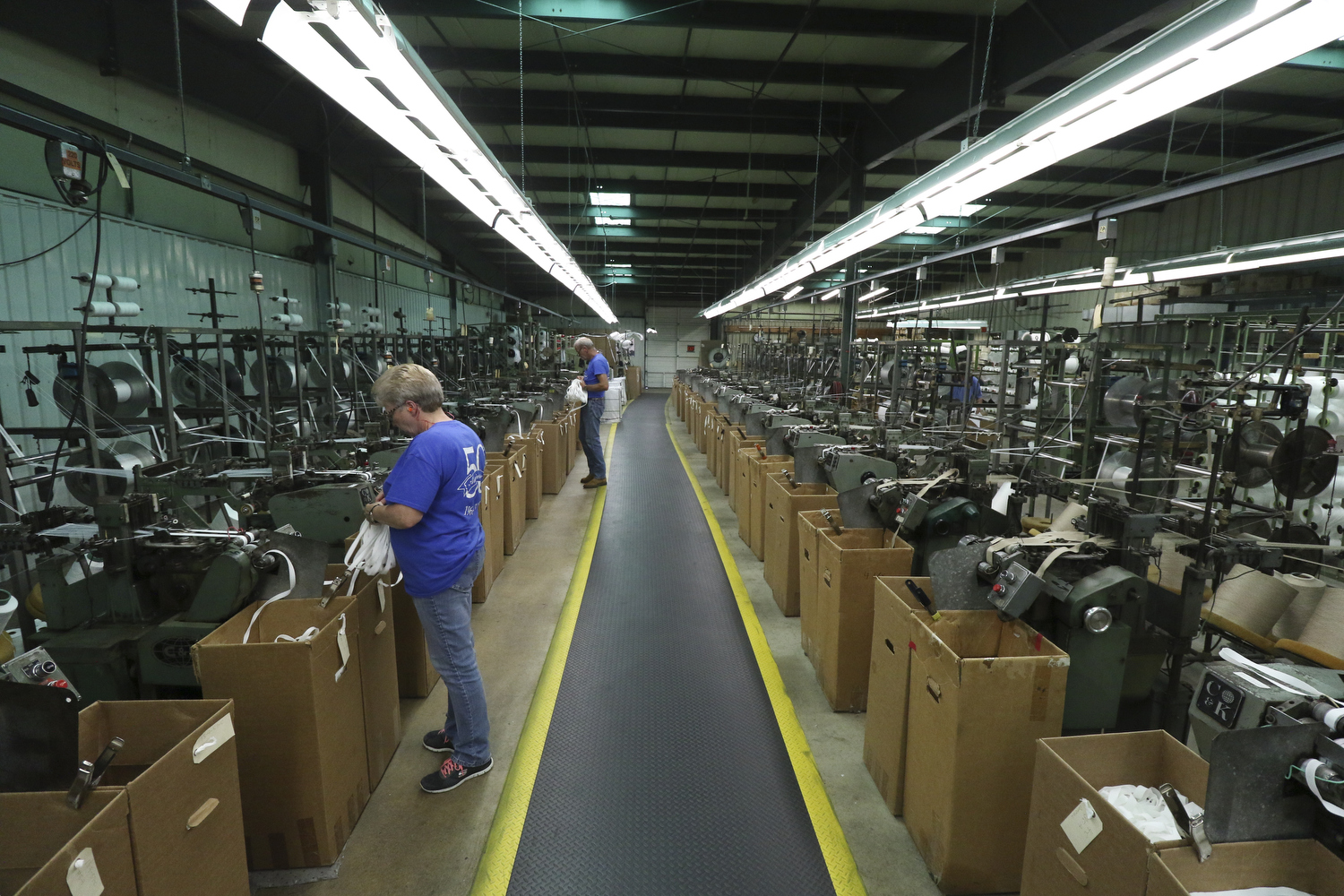 Staff Photo by Dan Henry / The Chattanooga Times Free Press- 7/25/16. Ann Hobbs, left, a 45-year employee at Dunlap Industries, and her coworker Randall Summers who has been with the company 32-years, quality check the tape being made for zipper manufacturing on Monday, July 25, 2016. DI makes molded and coil zippers for use with U.S. Army and other high use applications.