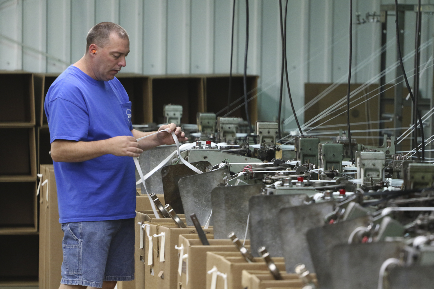Staff Photo by Dan Henry / The Chattanooga Times Free Press- 7/25/16. Billy Lee, a 28-year employee of Dunlap Industries, inspects tape that is being made for use with zippers on Monday, July 25, 2016. DI makes molded and coil zippers for use with U.S. Army and other high use applications.