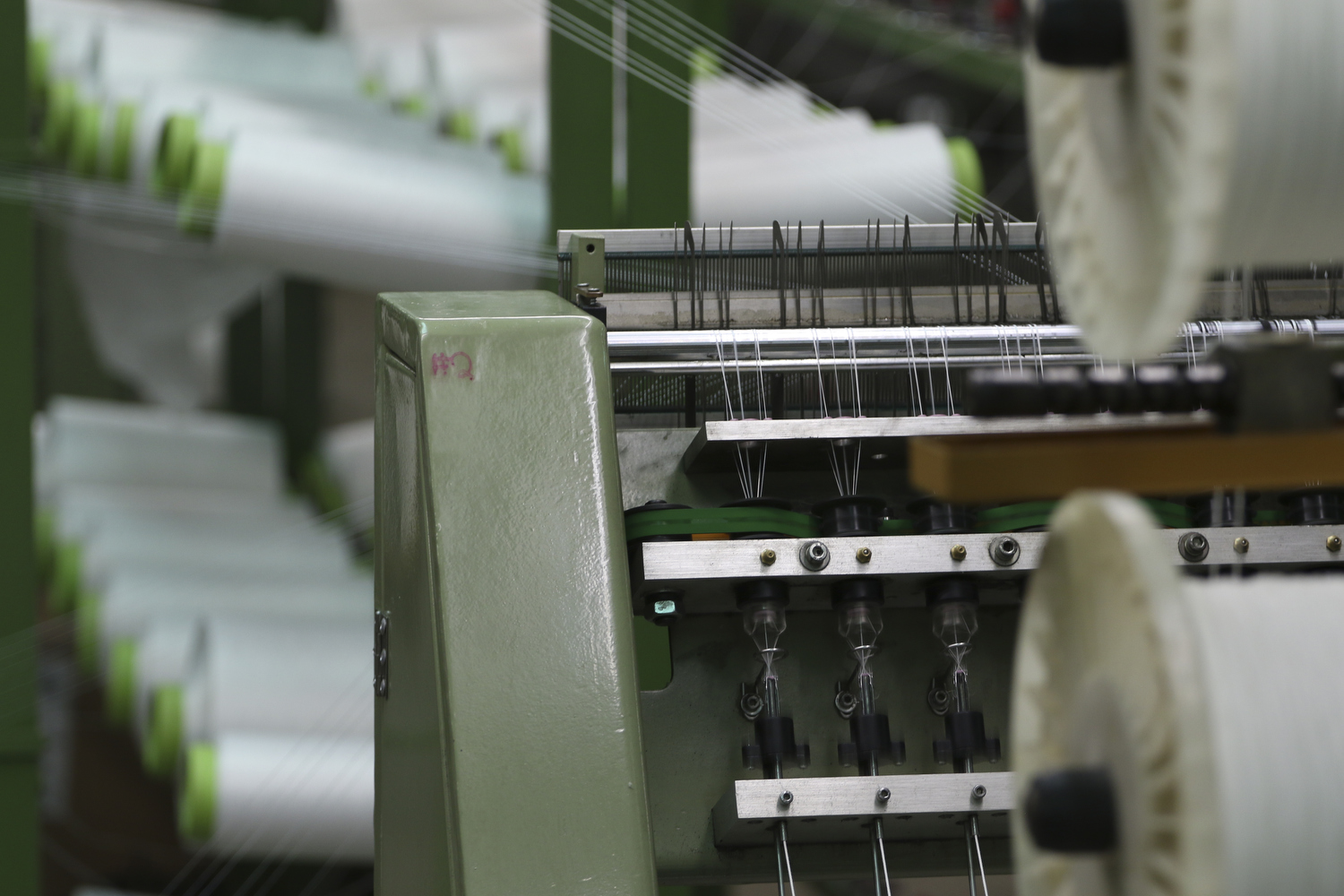 Staff Photo by Dan Henry / The Chattanooga Times Free Press- 7/25/16. Spools on a creel feed into machines weaving the tape used to make zippers at Dunlap Industries on Monday, July 25, 2016. DI makes molded and coil zippers for use with U.S. Army and other high use applications.