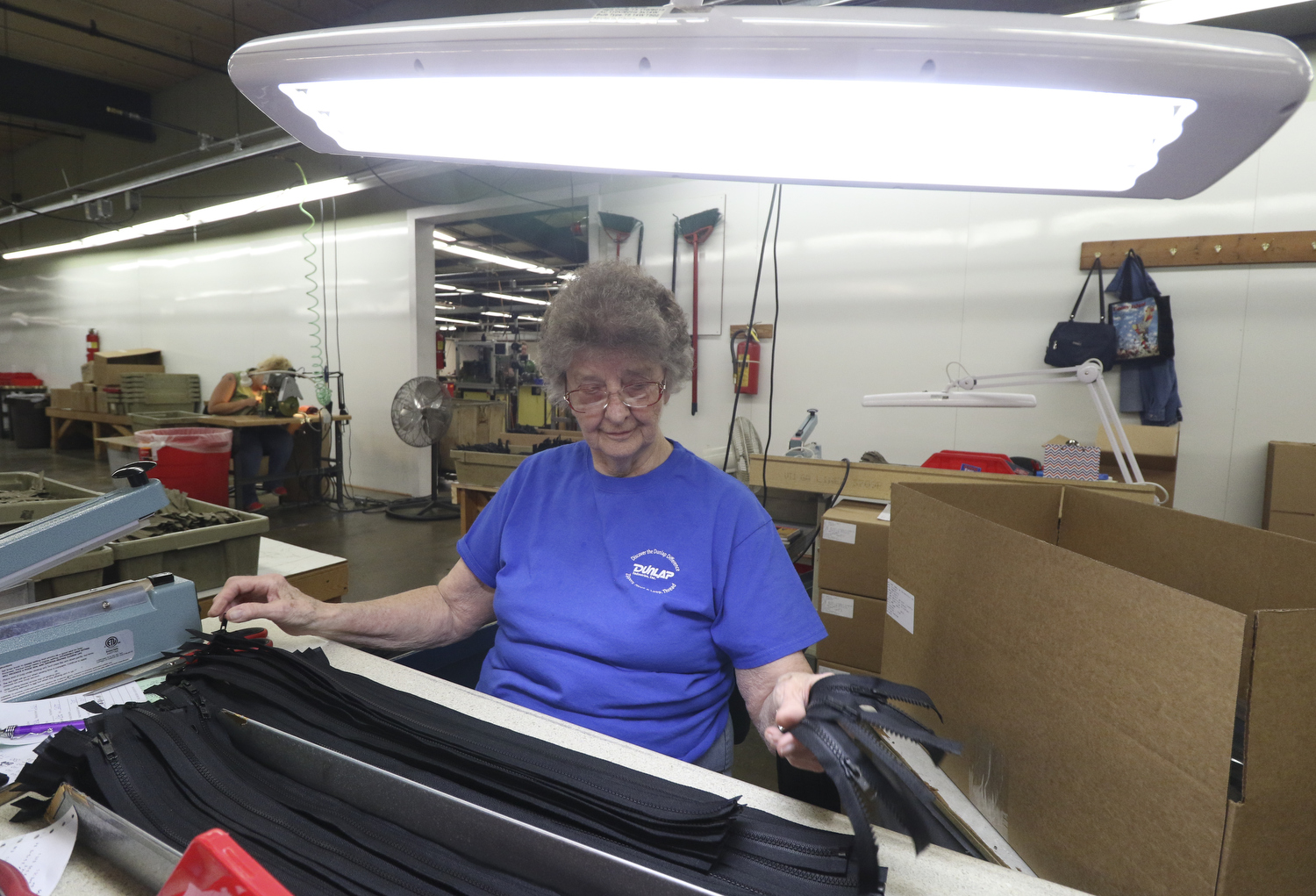 Staff Photo by Dan Henry / The Chattanooga Times Free Press- 7/25/16. Geneva Burch, a 29-year employee with Dunlap Industries, performs a final imspection on newly made zippers Monday, July 25, 2016. DI makes molded and coil zippers for use with U.S. Army and other high use applications.