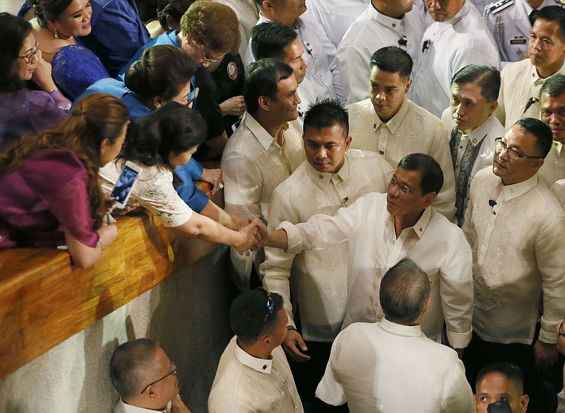 
              Philippine President Rodrigo Duterte is congratulated by supporters shortly after delivering his first State of the Nation Address at the 17th Congress Monday, July 25, 2016, in suburban Quezon city northeast of Manila, Philippines. Duterte declared a unilateral cease-fire with communist guerrillas effectively immediately Monday and asked the rebels to do the same to end decades of deadly violence and foster the resumption of peace talks. (AP Photo/Bullit Marquez)
            