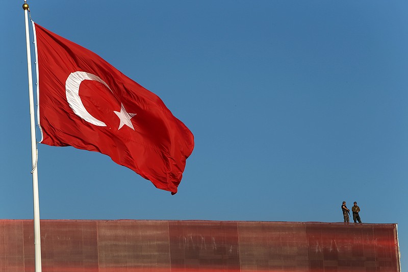 
              Police officers stand on a building roof overlooking a 'Republic and Democracy Rally' at Taksim square in central Istanbul, Sunday, July 24, 2016. Thousands of supporters of Turkey's main opposition group and some ruling party members rallied in Istanbul to denounce a July 15 coup attempt, a rare show of political unity that belied opposition unease over President Recep Tayyip Erdogan's crackdown since the failed uprising. (AP Photo/Petros Karadjias)
            