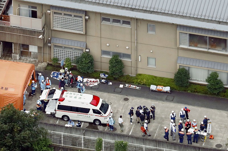 Ambulance crew and police officers are seen outside a facility for the handicapped where a number of people were killed and dozens injured in a knife attack Tuesday, July 26, 2016, in Sagamihara, outside Tokyo.