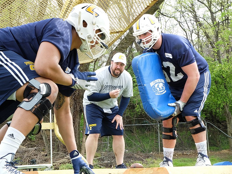 Offensive Line Coach Adam Ross, center, works Kennington Cadwell, left, and Corey Levin (62) on Wednesday. It was the third day of spring practice at Scrappy Moore Field.