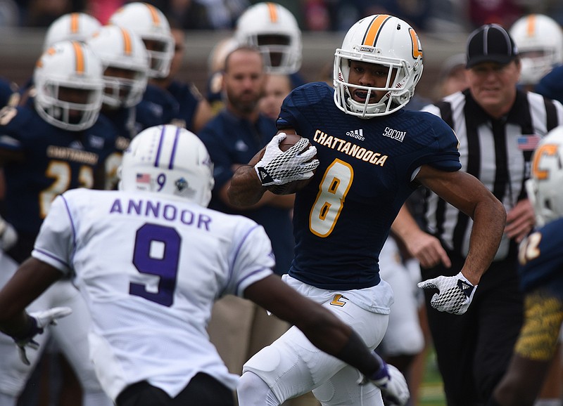 UTC's C.J. Board carries as Furman's Aaquil Annoor approaches at Finley Stadium on Saturday, October 10, 2015.