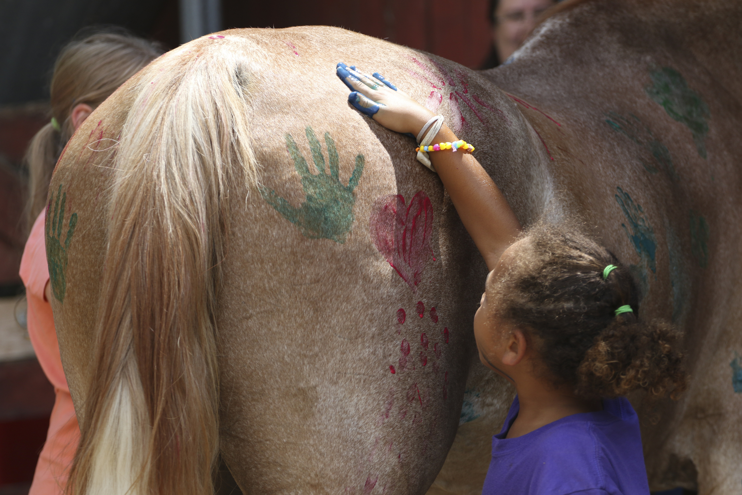 Brynlie Blue, 6, puts a hand print on "Apollo."