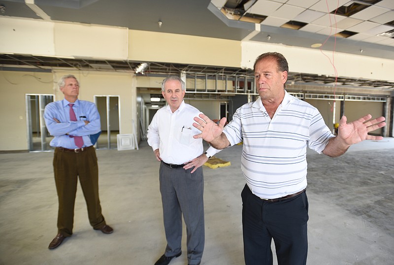 Emerson Russell, right, Joe Prebul, center, and Steve Olsen talk about CarExpress, a planned new car dealership near Shallowford Road.