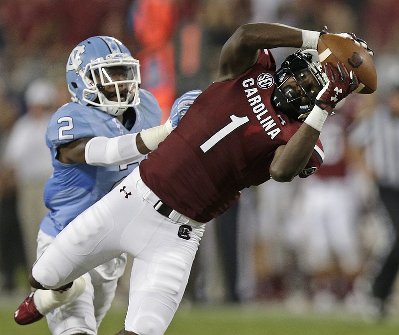 South Carolina's Deebo Samuel (1) reaches for a pass as North Carolina's Des Lawrence (2) defends in the second half of an NCAA college football game in Charlotte, N.C., Thursday, Sept. 3, 2015. The pass was incomplete. South Carolina won 17-13. (AP Photo/Chuck Burton)