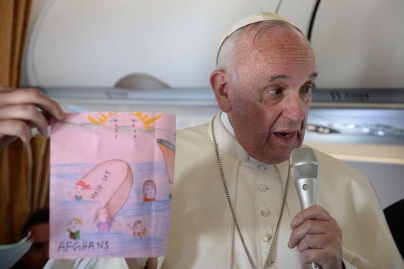 
              FILE -- In this April 16, 2016 file photo, Pope Francis shows a drawings made by children on his flight back to Rome following a visit to the Greek island of Lesbos. The pontiff’s advocacy for refugee rights faces a diplomatic test Wednesday when he begins a five-day visit to Poland, where a populist government has slammed the door on most asylum seekers. (Filippo Monteforte/Pool Photo via AP)
            