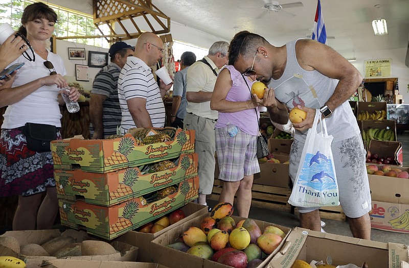
              FILE - In this Tuesday, June 9, 2015, file photo, shopper Miguel Ramirez smells a mango before purchasing at a local fruit store in the Little Havana area of Miami. On Tuesday, July 26, 2016, the Conference Board releases its July index on U.S. consumer confidence. (AP Photo/Alan Diaz, File)
            