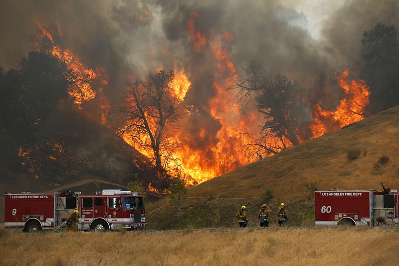 
              A hillside erupts in flame as a wildfire burns in Placerita Canyon in Santa Clarita, Calif., Monday, July 25, 2016. A raging wildfire that forced thousands from their homes on the edge of Los Angeles continued to burn out of control Monday as frustrated fire officials said residents reluctant to heed evacuation orders made conditions more dangerous and destructive for their neighbors. (AP Photo/Nick Ut)
            