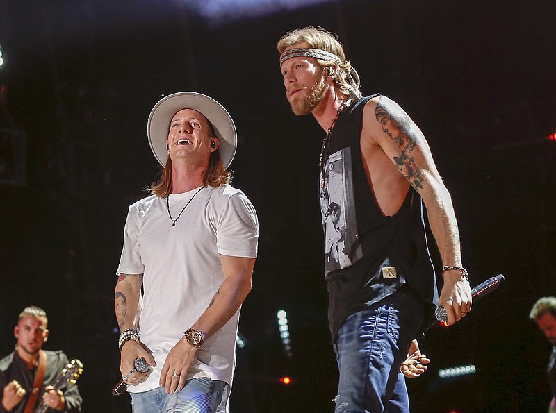 
              FILE - In this June 11, 2016 file photo, Tyler Hubbard, left, and Brian Kelly of Florida Georgia Line perform at the CMA Music Festival in Nashville, Tenn. The country duo said it was misunderstanding after police agencies in two states said the duo didn’t want any armed officers backstage during their shows. They said in a statement Tuesday, July 26, it was “redundant for us to use local authorities” when security was already present and said they have an enormous amount of respect for police. (Photo by Al Wagner/Invision/AP, File)
            