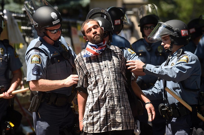 
              Joshua Lawrence is arrested by St. Paul police after protesters refused to move from in front of the Governor's residence on Summit Ave. in St. Paul, Minn. on Tuesday, July 26, 2016. Police have arrested an unknown number of protesters in front of the governor's mansion on St. Paul's Summit Avenue. Demonstrators have been camping outside the governor's residence since early July 7, a day after the shooting of Philando Castile, who was killed by a St. Anthony police officer during a traffic stop. (Scott Takushi/Pioneer Press via AP)
            